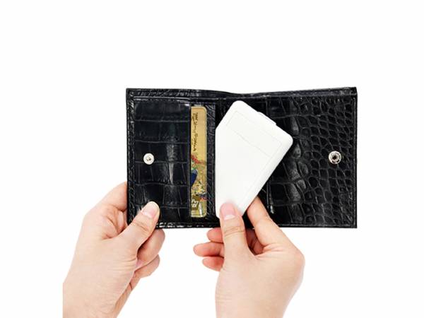 Hand hält eine schwarze, glänzende Geldbörse mit Kartenfächern und einem RFID-Schutzmechanismus für Sicherheit.