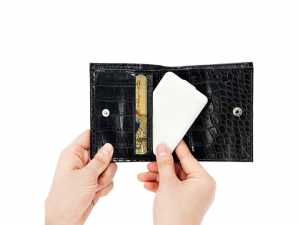 Hand hält eine schwarze, glänzende Geldbörse mit Kartenfächern und einem RFID-Schutzmechanismus für Sicherheit.