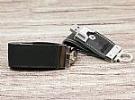 Leder-USB-Stick in Schwarz mit silbernem Metallverschluss und Platz für individuelles Logo. Praktisch und elegant.