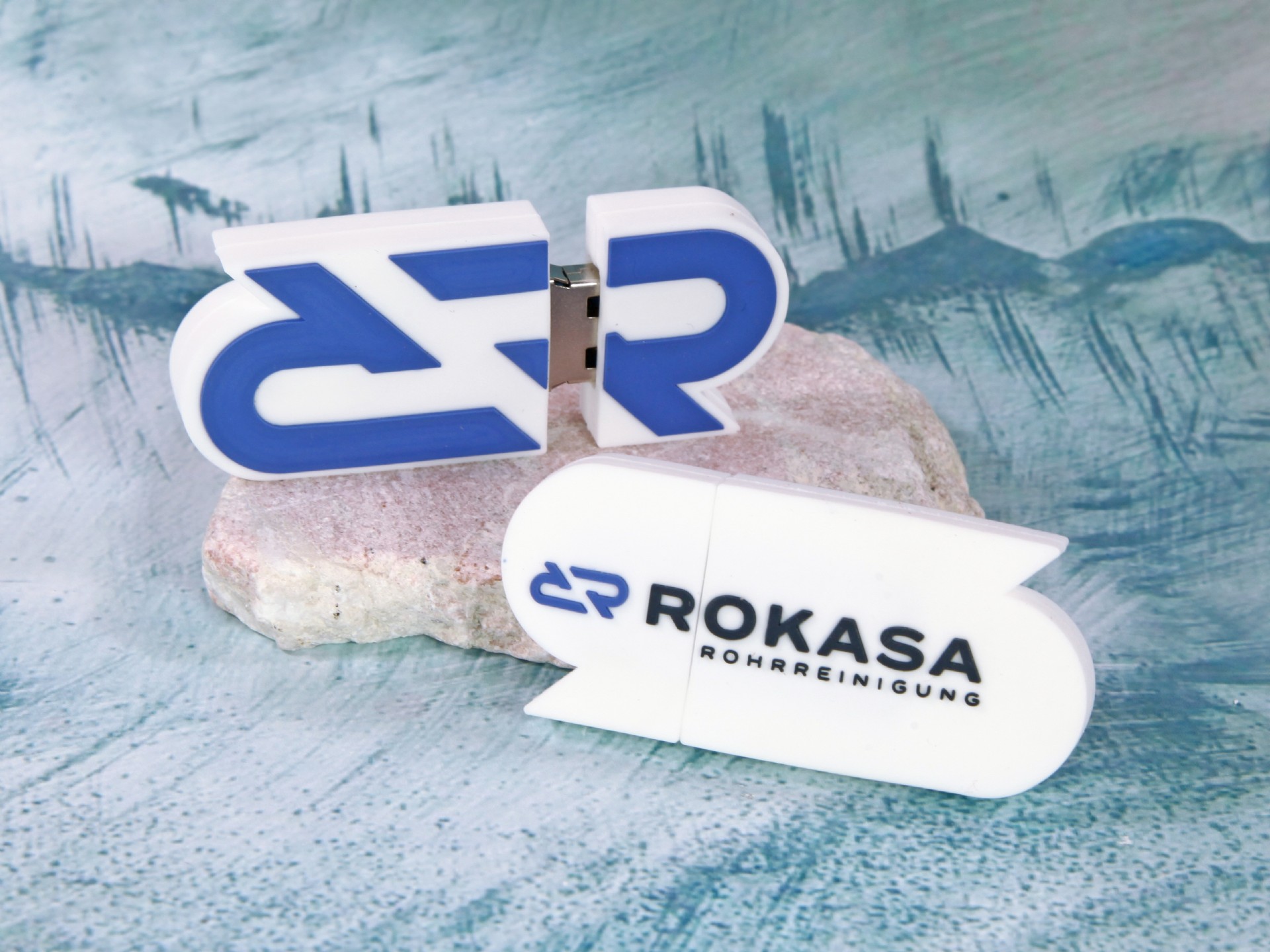 Werbe-USB-Stick in kreativer Freiform mit blau-weißer Farbgestaltung und Platz für individuelles Logo.